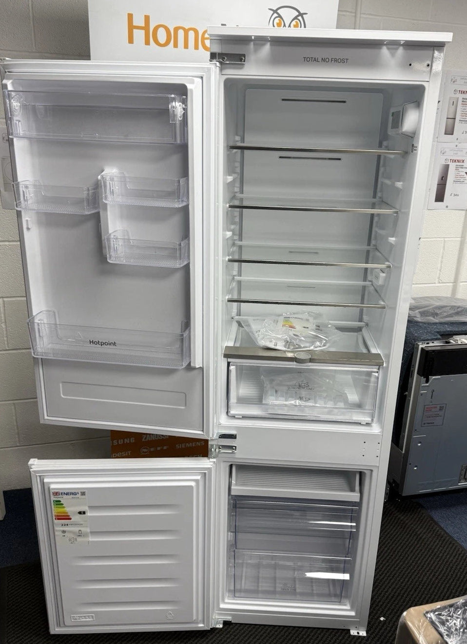 Hotpoint HTC18 T112 UK 70/30 No Frost Integrated Fridge Freezer with Sliding Hinge - E Rated from HomeWise Appliances. Shop photo of the front with the doors open showing the interior contents.