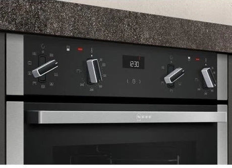 Neff N50 J1ACE2HN0b Double Built under Oven from HomeWise Appliances. Stock photo showing close up of the control panel with dials and clock.