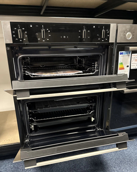 Neff N50 J1ACE2HN0b Double Built under Oven from HomeWise Appliances. Showroom photo sh wing front of the oven with doors open and internal furniture on display.