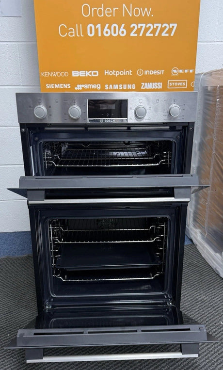 Bosch Series 2 MHA133BR0B (79) Built In Electric Double Oven in Stainless Steel from HomeWise Appliances. Showroom photo showing front of oven with doors open and a close up of interior of the cavities complete with trays and wire racks.