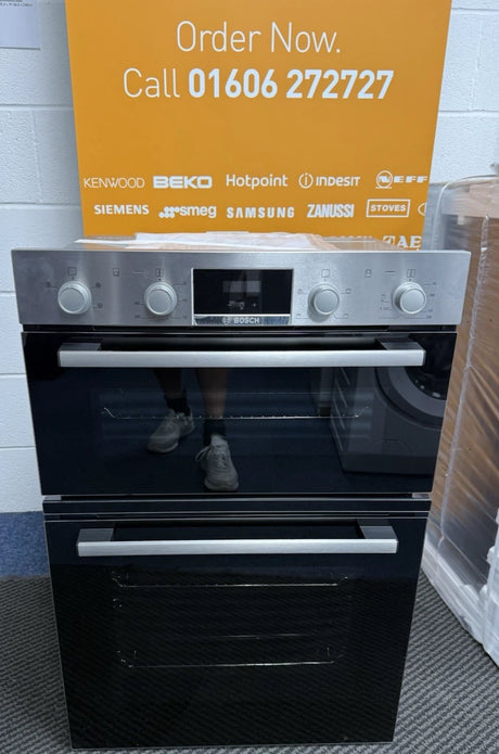 Bosch Series 2 MHA133BR0B (79) Built In Electric Double Oven in Stainless Steel from HomeWise Appliances. Showroom photo showing oven in front of a call to action sales banner. Order Now. Call  01606 272727.
