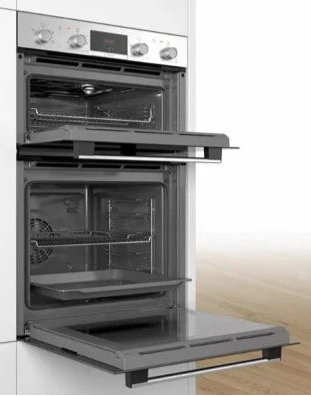 Bosch Series 2 MHA133BR0B (79) Built In Electric Double Oven in Stainless Steel from HomeWise Appliances. Stock photo showing oven in a kitchen cabinet. Oven doors are open showing fan assisted oven and internal furniture.